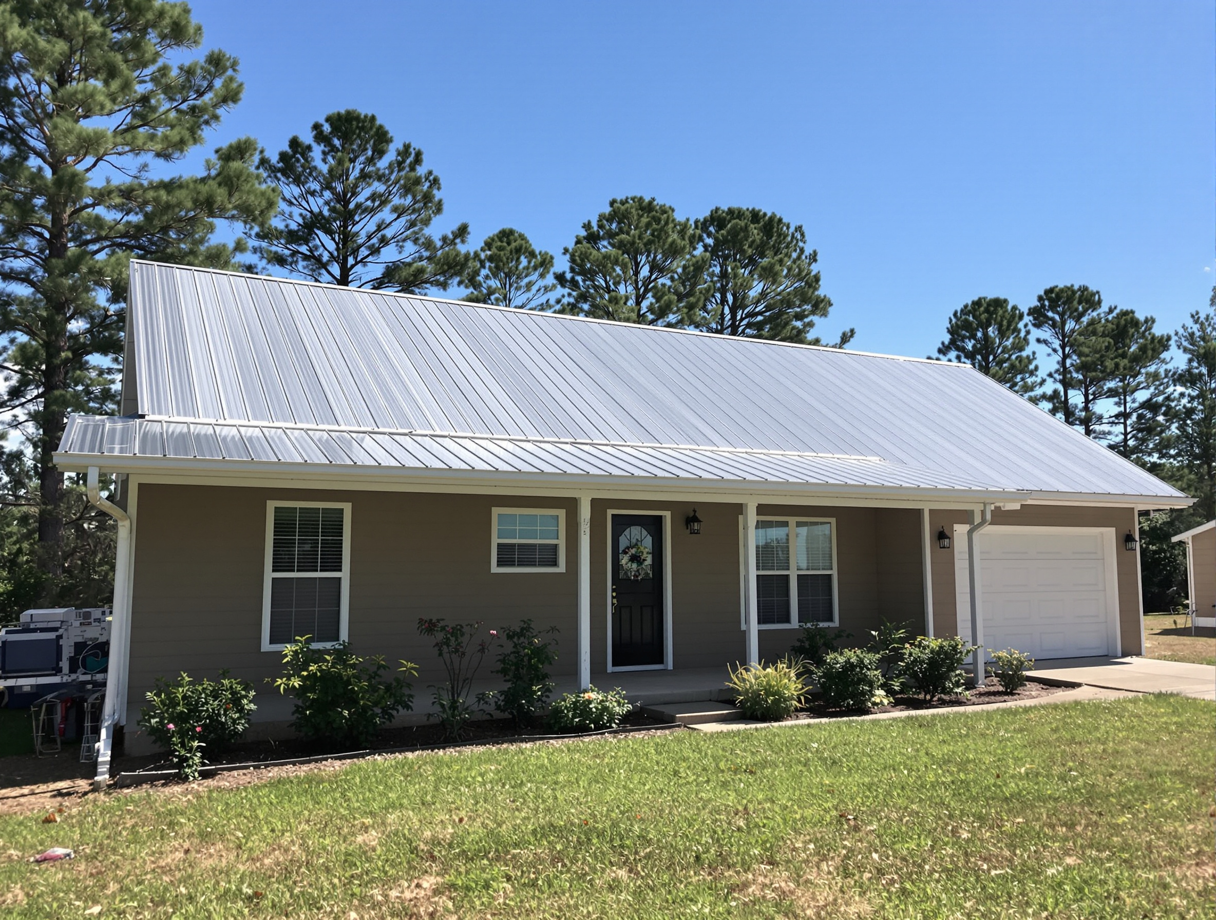Same ranch home now with new galvalume R-panel exposed-fastener metal roof and new gutters — after replacement looking refreshed